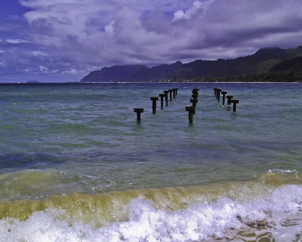 Rusting pier posts at a beach in Oahu, Hawaii