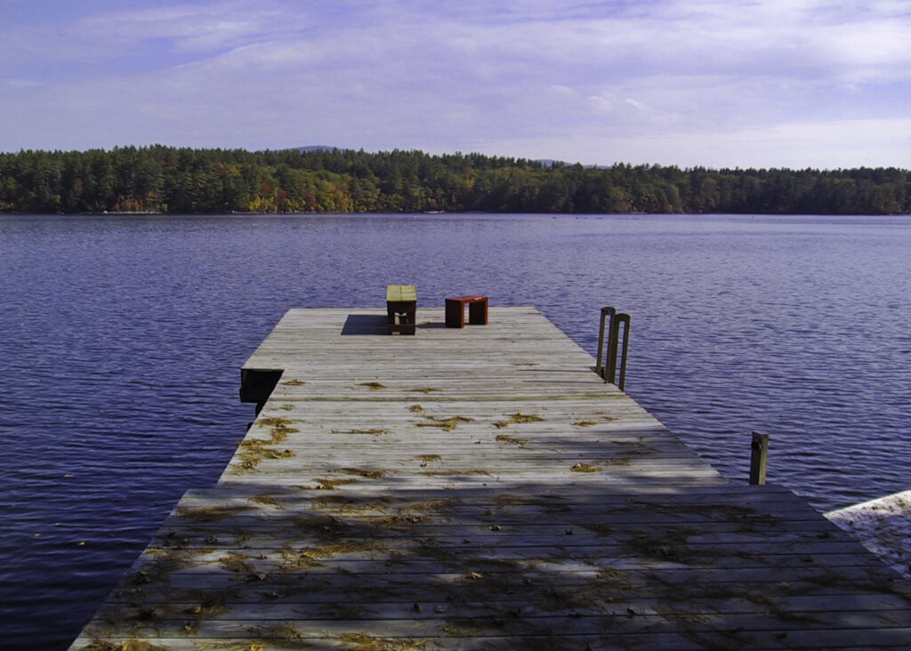 The dock at Squam, autumn leaves can be seen across the lake on Great Island.