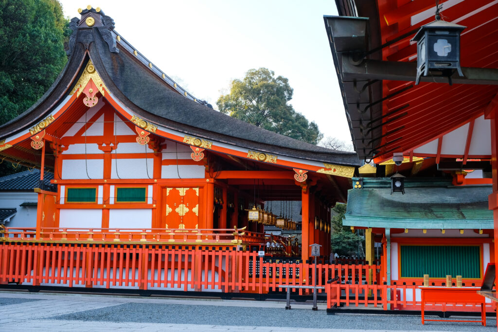 Another view of the Fushimi Inari shrine, decorated in white and bright orange with gold accents.