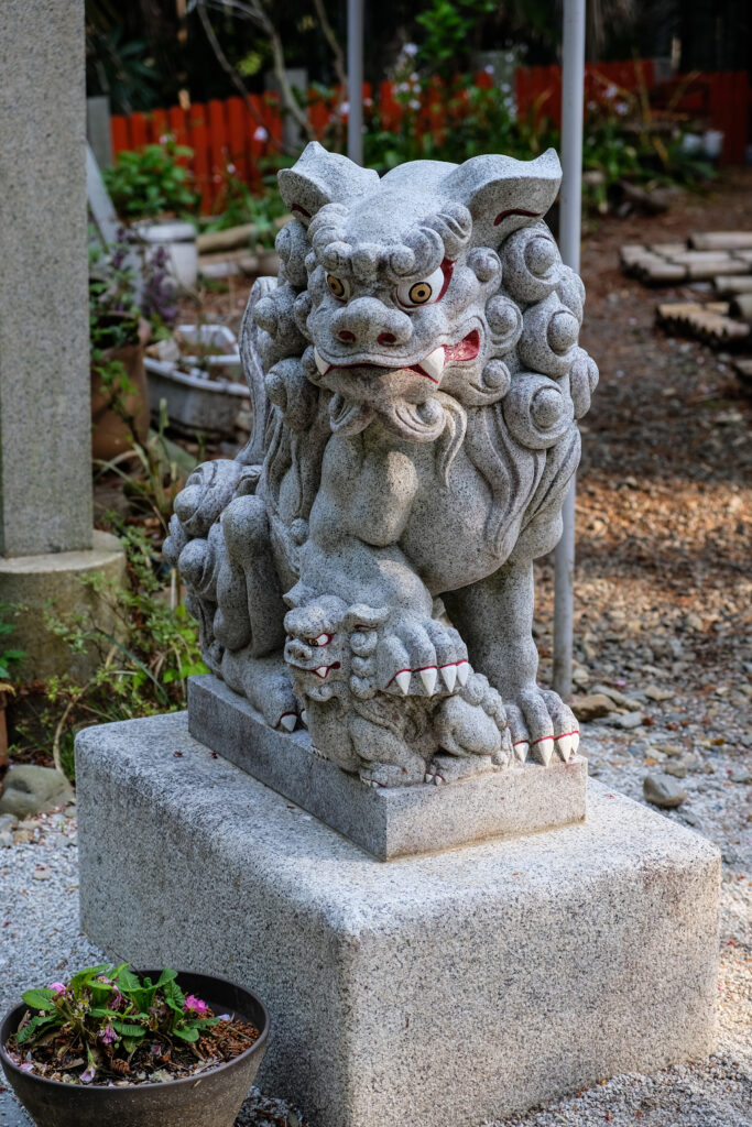 Statues of Komainu (lion dogs), with a smaller komainu under the paw of a larger one.