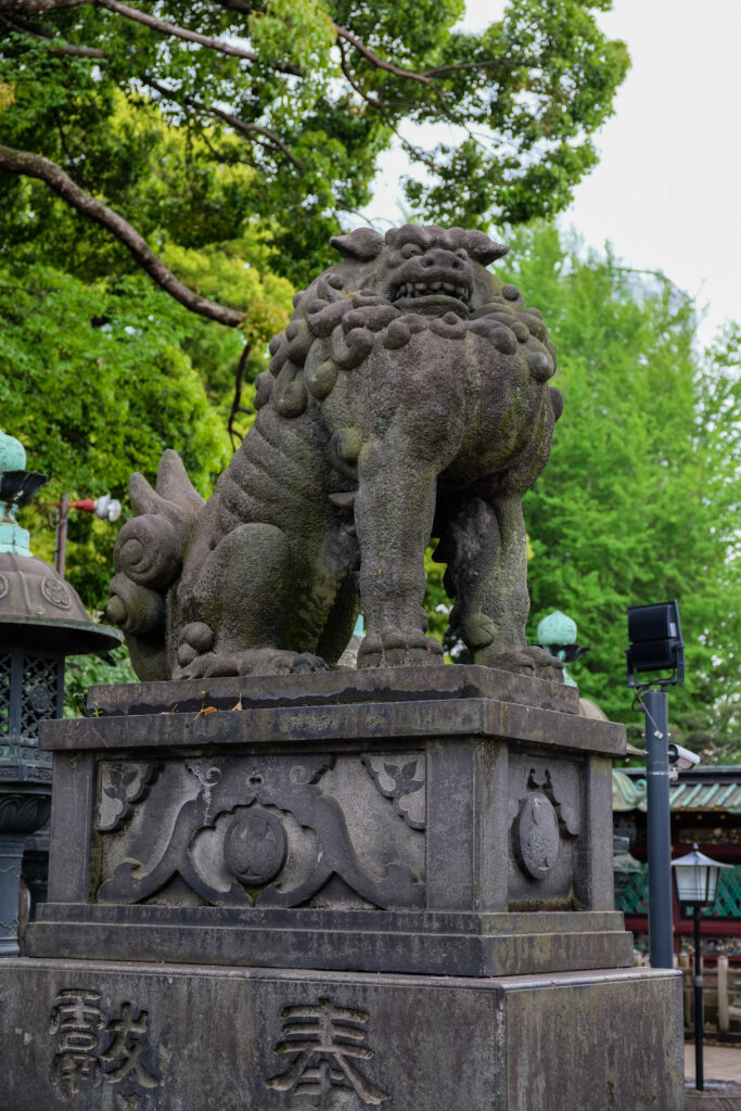 A large komainu statue looks down at the camera.